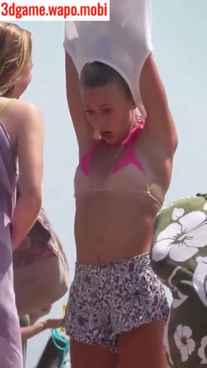 young girl undresses on the beach